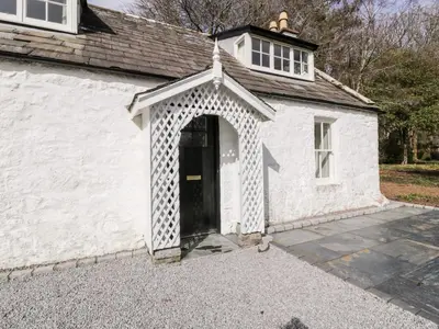 a white building with a door and a window at Saltflats Cottage - Rockcliffe in Dalbeattie