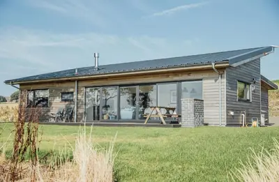 a house with large windows on the side of it at Cairn Dyke Lodge in Gatehouse of Fleet