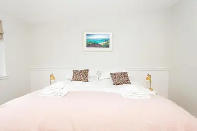 a white bed with white sheets and pillows on it at Cairn Dyke Lodge in Gatehouse of Fleet