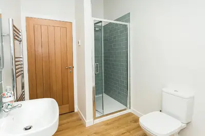 a bathroom with a shower and a toilet and a sink at Cairn Dyke Lodge in Gatehouse of Fleet