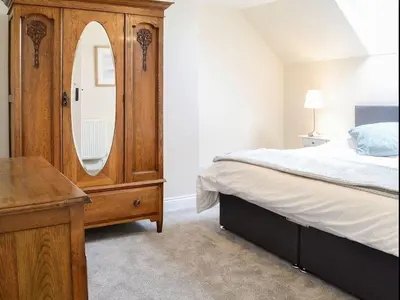 a bedroom with a wooden dresser and a large mirror at Blackloch in Gatehouse of Fleet