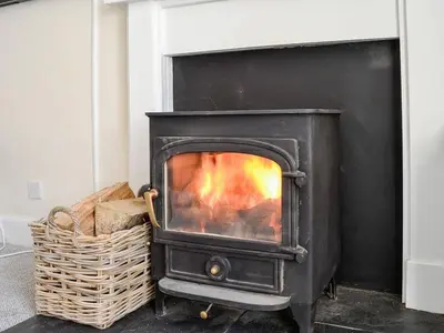 a black stove with a fire in a room at Blackloch in Gatehouse of Fleet