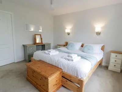a bedroom with a large bed with blue towels on it at Knockendoch in Dumfries