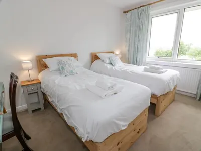 two twin beds in a room with a window at Knockendoch in Dumfries