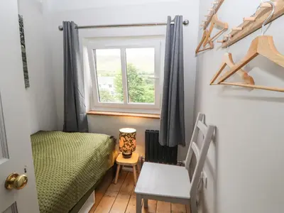 a small bedroom with a bed and a window at Beech Croft in Keswick