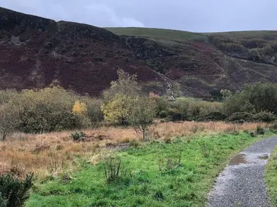 a dirt road in a field with a mountain at Lakeland Retreat in Lamplugh