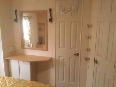 a bedroom with a mirror next to a door at Lakeland Retreat in Lamplugh