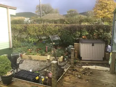 a backyard with a garden with a fence at Lakeland Retreat in Lamplugh