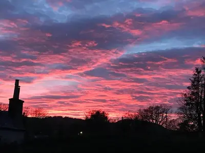 a sunset with a building and a red sky at Polharrow in Dalry