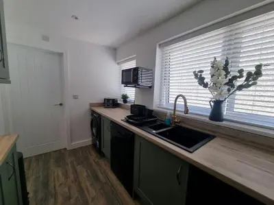 a kitchen with a counter with a sink and a window at Home from home in Maryport in Maryport
