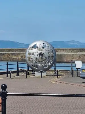 a metal sculpture on the side of a pier at Home from home in Maryport in Maryport
