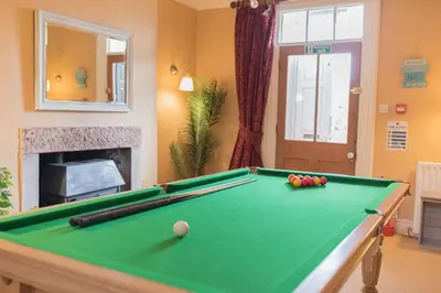 a billiard table in a living room with a pool table at Abbey Farm House in St Bees