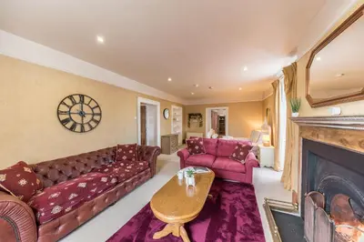 a living room with a couch and a fireplace at Abbey Farm House in St Bees