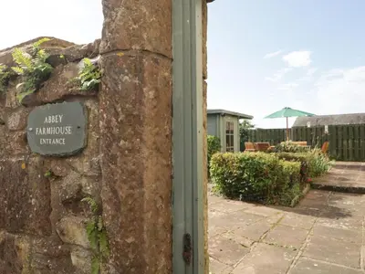 a sign on the side of a stone building at Abbey Farm House in St Bees