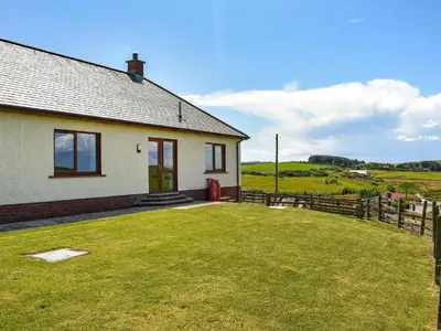 a house with a grass yard in front of it at Little Glengyre Farm in Kirkcolm