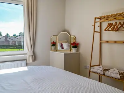 a bedroom with a bed and a window at Southways Cottage in Cumwhinton