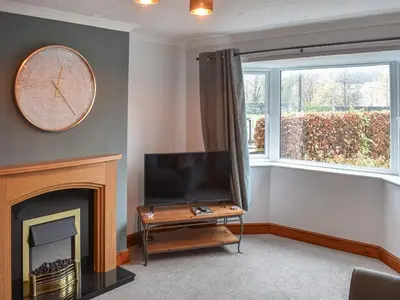 a living room with a tv and a fireplace at Tynedale in Keswick