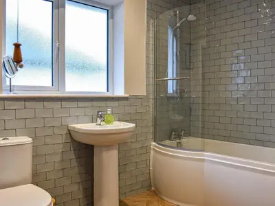 a bathroom with a sink and a toilet and a bath tub at Tynedale in Keswick