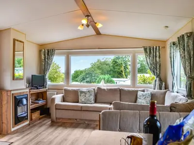 a living room with a couch and a large window at The Beachcomber in Palnackie