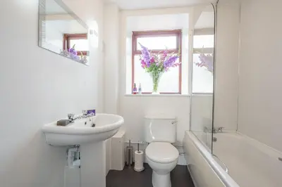a white bathroom with a toilet and a sink at Thomas Carlyle Cottage in Thornhill