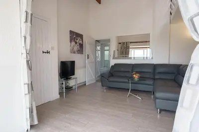 a living room with a blue couch and a tv at Jane Welsh Cottage in Thornhill