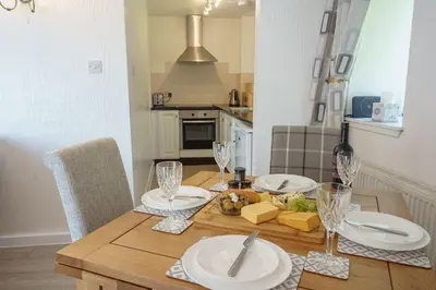 a dining room table with plates and wine glasses at Jane Welsh Cottage in Thornhill