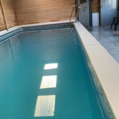 a swimming pool with blue water in a building at Dalgarnock Cottage in Thornhill