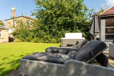 a living room with two couches and an umbrella at Burnock Lodge with Hot Tub in Ayr