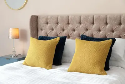 a bed with two yellow pillows and a headboard at Cottage - Sleeps 4 hot tub & pet friendly in Carlisle