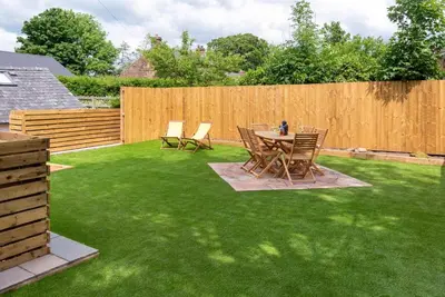 a backyard with a table and chairs on grass at Cottage - Sleeps 4 hot tub & pet friendly in Carlisle