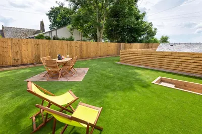 a lawn with chairs and a table and a fence at Cottage - Sleeps 4 hot tub & pet friendly in Carlisle