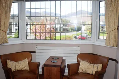 two chairs and a table in front of a window at Riverside Escape in Keswick