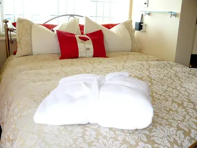 a bed with red and white pillows on it at Riverside Escape in Keswick
