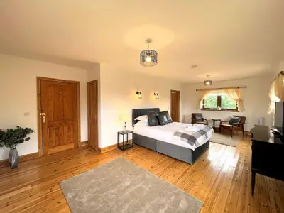 a bedroom with a bed and a living room at Spectacular 7BR House Hot Tub and Gardens in Gretna - Pass the Keys in Gretna Green