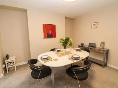 a dining room with a white table and chairs at Bay Tree Cottage in Keswick