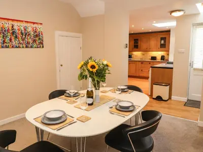 a dining room with a white table and chairs at Bay Tree Cottage in Keswick