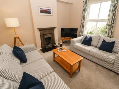 a living room with two couches and a fireplace at Bay Tree Cottage in Keswick