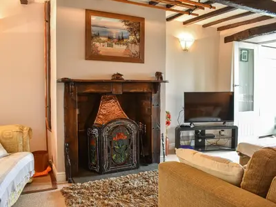 a living room with a fireplace and a tv at High Spy in Bassenthwaite