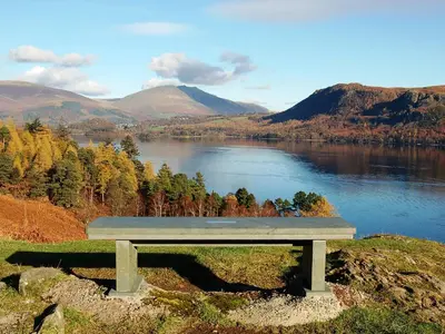 a bench sitting on top of a hill overlooking a lake at High Spy in Bassenthwaite