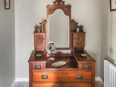 a wooden dresser with a mirror on top of it at The Nook - Uk44735 in Tallentire