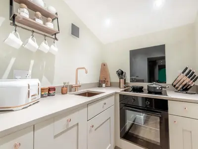 a kitchen with white cabinets and a sink and a microwave at The Nook - Uk44735 in Tallentire