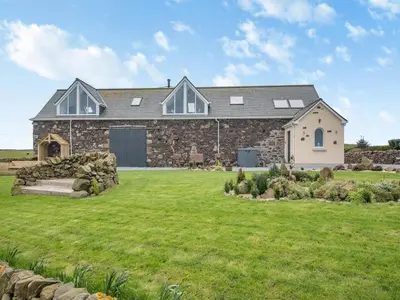 a large stone house with a large yard at Seascape Barn in Kirkcolm
