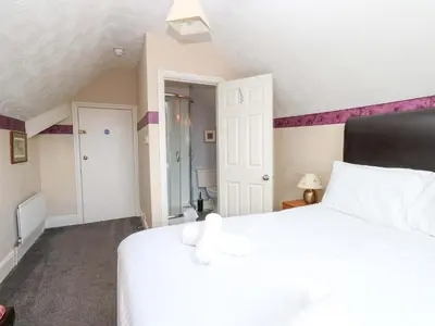a bedroom with a white bed and purple walls at Fern Lee in Carlisle