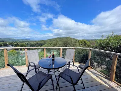 a table and four chairs on a wooden deck at Gorgeous Kippford Home With Outstanding Views - Pass the Keys in Kippford