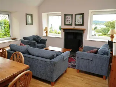 a living room with couches and a table and a fireplace at Seabank Cottage in Rockcliffe