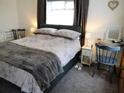 a bedroom with a bed and a desk and a window at Kippford Stables in Kippford