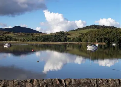 a lake with two boats in the water at Kippford Stables in Kippford