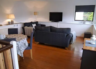 a living room with a couch and a table at Kippford Stables in Kippford