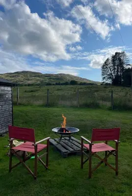two chairs and a fire pit in a yard at Rowantree Cottage in Gatehouse of Fleet
