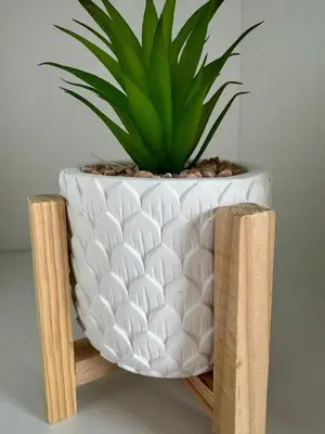 a plant in a white vase sitting on a wooden stand at Harbourside Apartment - 1 Bedroom - Sleeps 2 in Whitehaven
